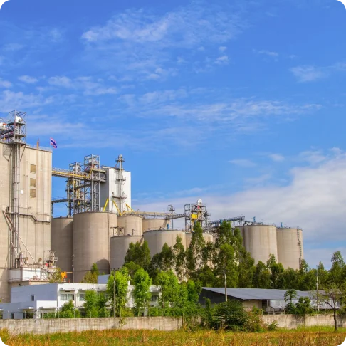 White cement silo with steel support structure against blue sky.