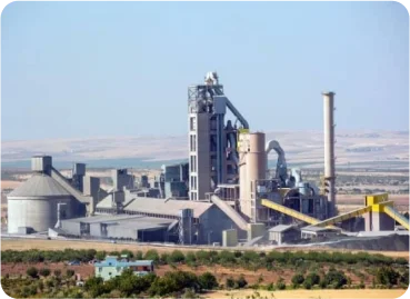 Large cement manufacturing plant with preheater tower and processing facilities.