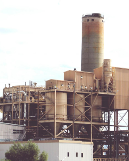 Industrial cement plant with preheater towers and tall chimney for clinker production